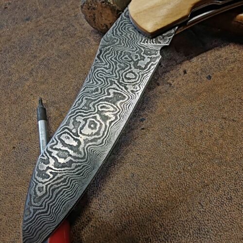 Couteau pliant artisanal avec lame en acier damas et manche en bois