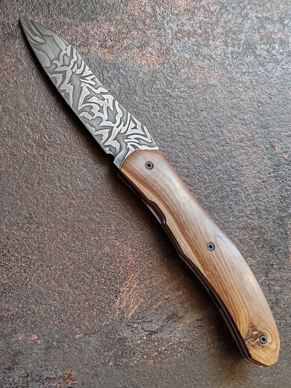 Couteau pliant artisanal avec lame en acier damas et manche en bois