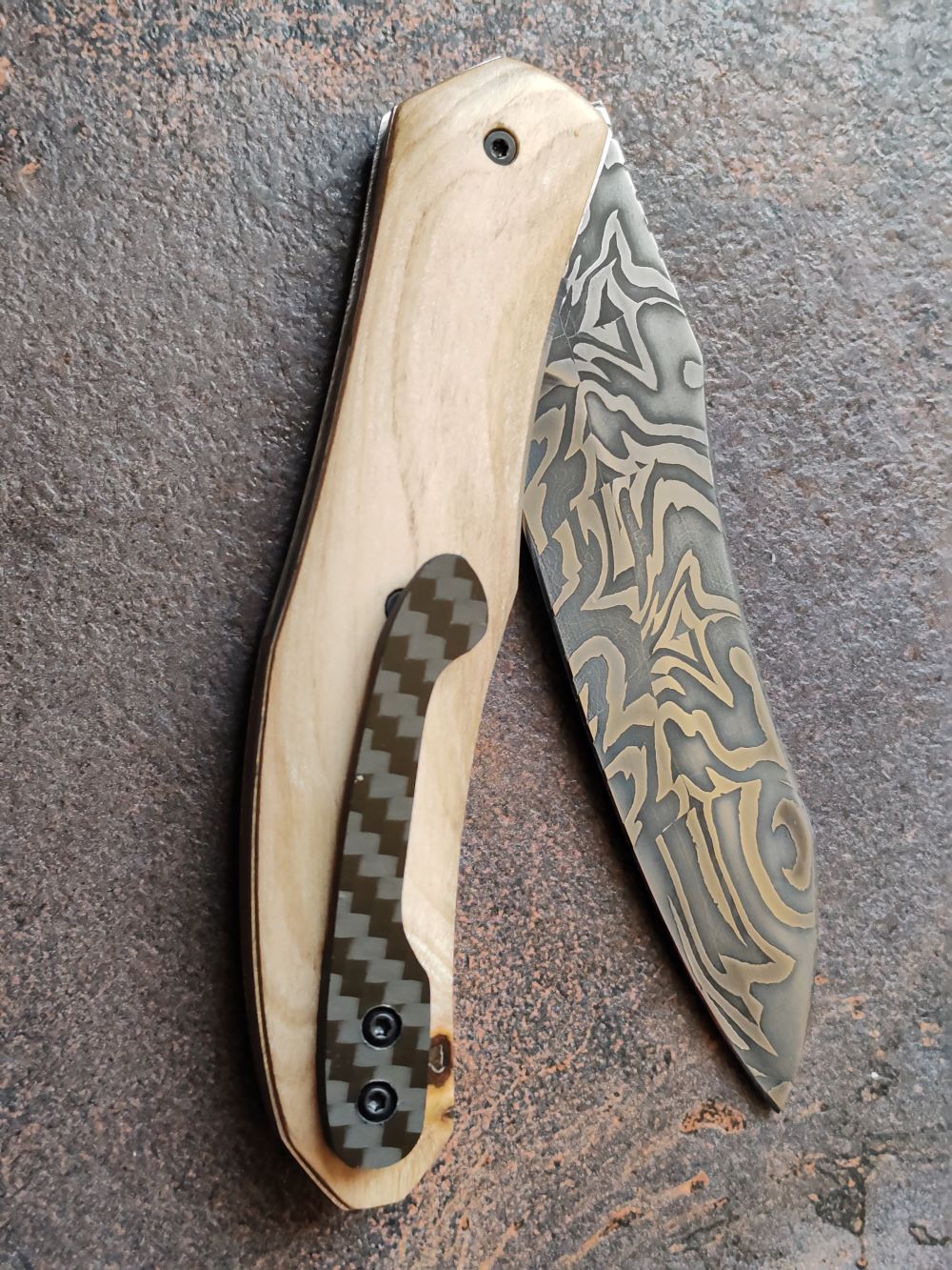 Couteau pliant artisanal avec lame en acier damas et manche en bois