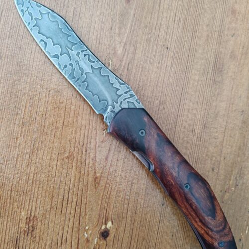 Couteau pliant artisanal avec lame en acier damas et manche en bois cocobolo