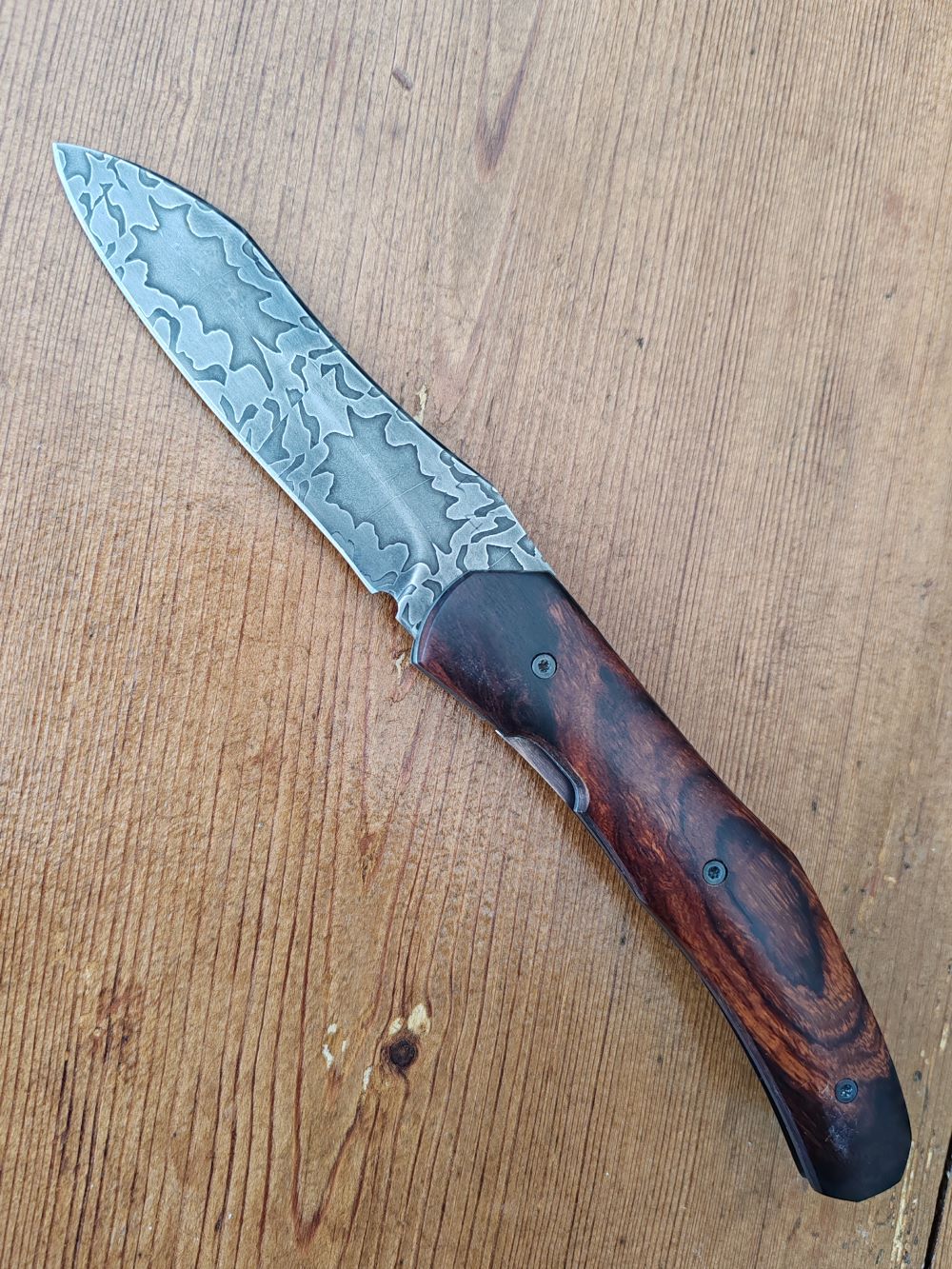 Couteau pliant artisanal avec lame en acier damas et manche en bois cocobolo