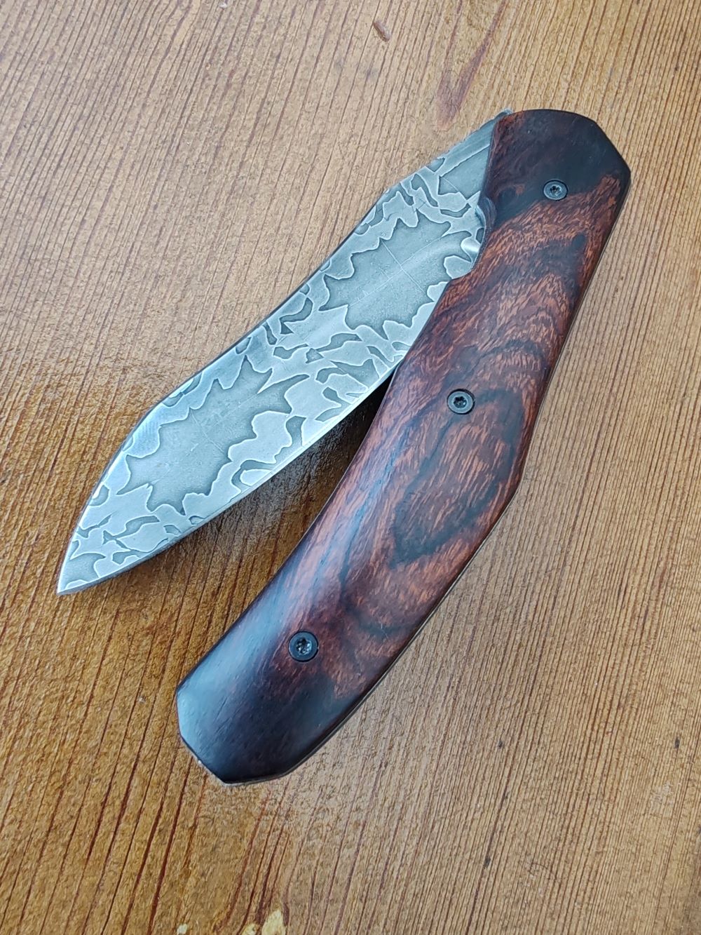 Couteau pliant artisanal avec lame en acier damas et manche en bois cocobolo